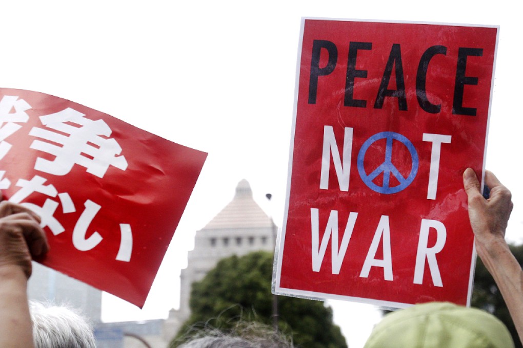 Protesters holding anti-war placards rally in front of the Parliament building in Tokyo to protest against the legislation that would expand the role of the nation's military. Photo: AP
