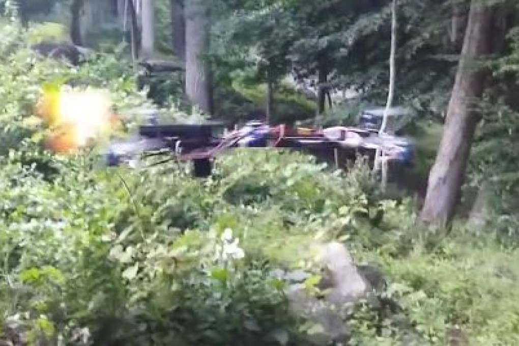 Muzzle flare is visible as a pistol mounted on a four-rotor drone fires in this still from a video. Photo: YouTube