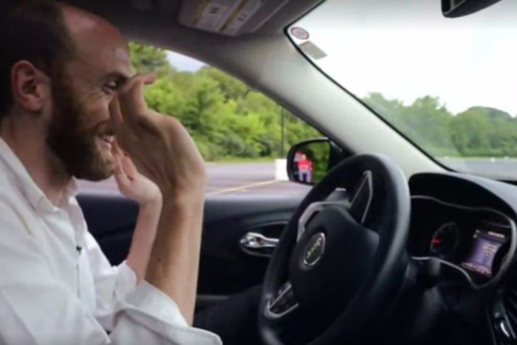 Wired journalist Andy Greenberg watches in bemusement as hackers commandeer the steering wheel of his Jeep Cherokee. The steering hack only worked at low speeds in reverse, but the hackers were able to switch off the car's engine while it was at highway speed. Photo: Wired