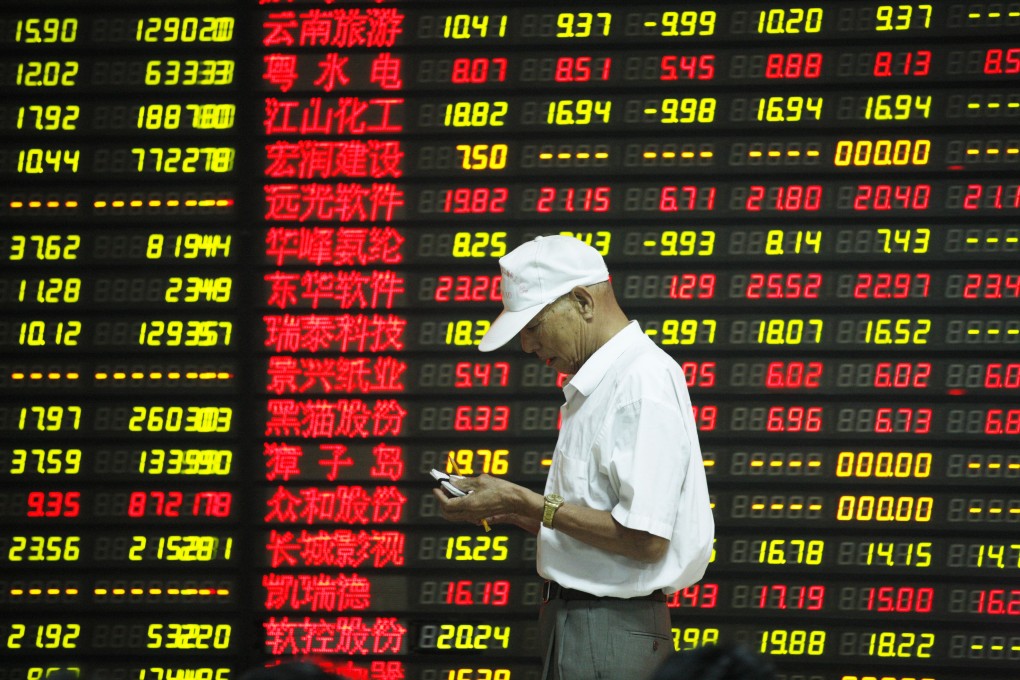 An investor in China is framed by an electronic board showing stock prices in the country's volatile equity markets. Photo: Xinhua