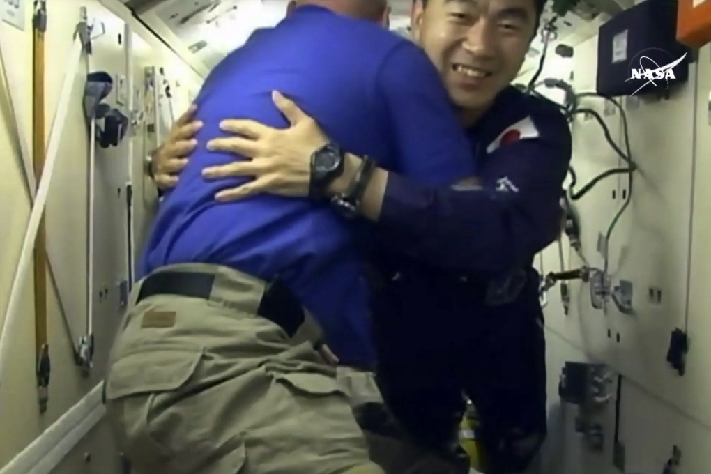 Japanese astronaut Kimiya Yui, right, is greeted as he boards the International Space Station, early Thursday. Photo: NASA/AP