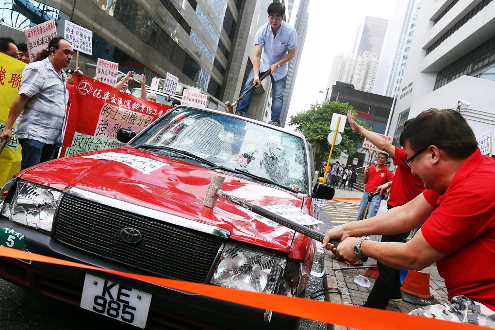 The cabbies smashed a red taxi in a symbolic show of their anger over competition from mobile car-hailing apps. Photo: Dickson Lee