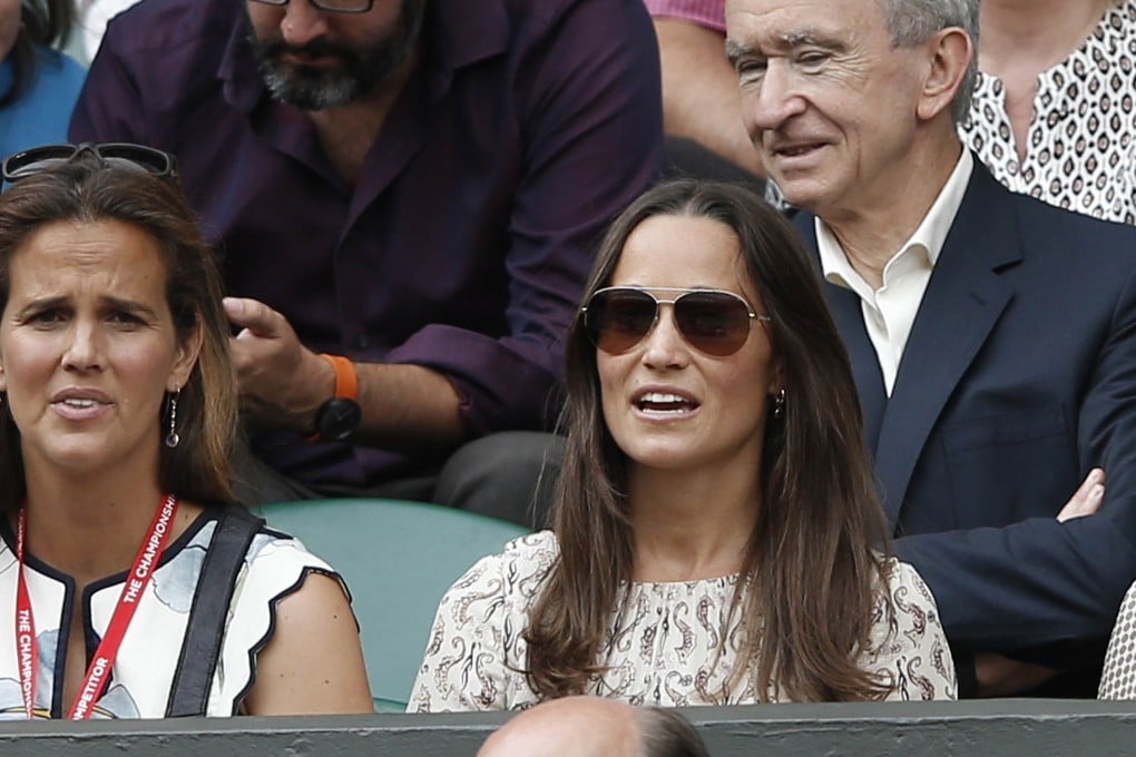 Pippa Middleton (centre), sister of the Duchess of Cambridge, wears the Adelaide Seahorse dress from Tory Burch's 2013 resort collection while watching the men's singles final at Wimbledon this month. Photo: AFP
