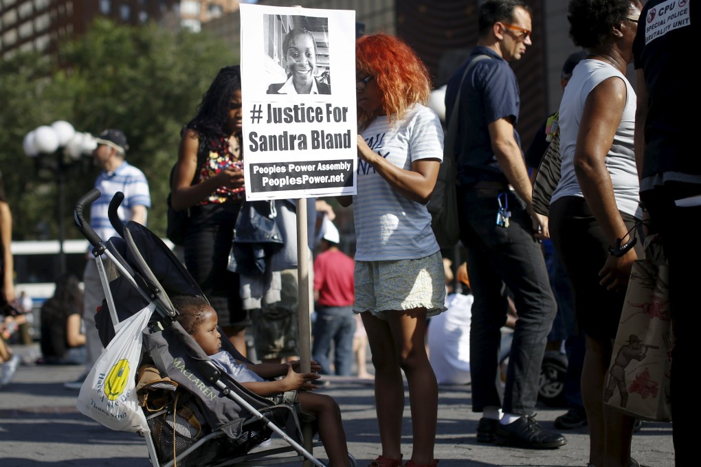 A child holds a sign of Sandra Bland, who died in police custody, during a rally against police violence. Photo: Reuters