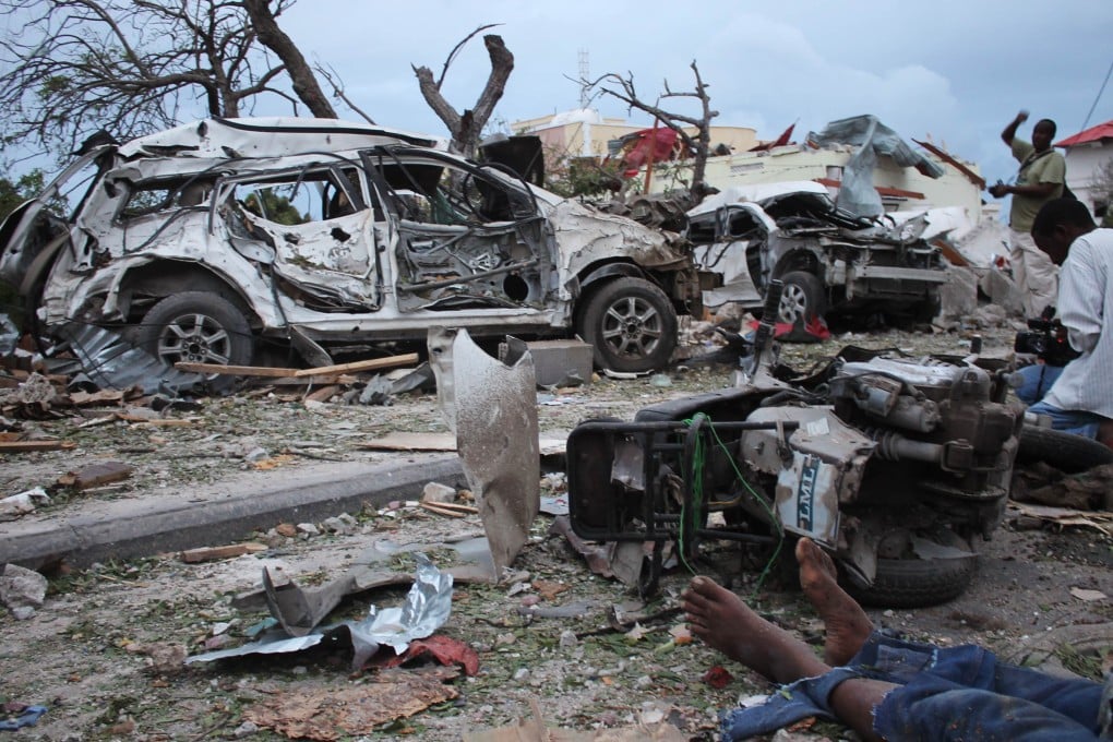 A body lies in the rubble next to damaged cars near the Jazeera Palace hotel following a suicide attack in Mogadishu. Photo: AFP