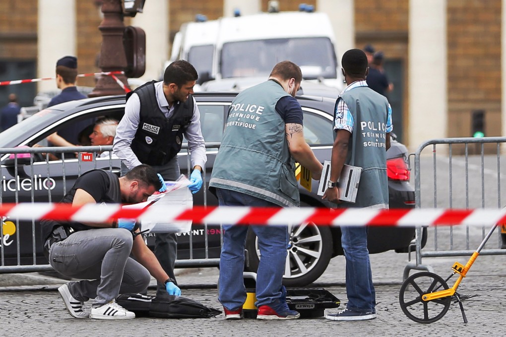 French police look for clues after a car drove through barriers set up for the final stage of the Tour de France in central Paris, France. Police opened fire on the car which drove through barriers. Photo: Reuters