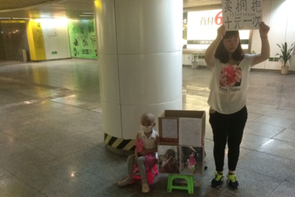 Chen Dejuan offers hugs for 10 yuan outside a subway station in Chingqing. Photo: SCMP Pictures