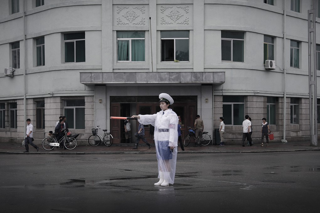 A traffic policewoman dressed in a raincoat directs traffic in Pyongyang, North Korea, as an economic downturn in neighbouring China could severely hit the country. Photo: AP