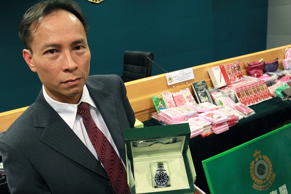 Guy Fong Wing-kai, commander in the department's technology crime investigation division with a counterfeit Rolex watch. Photo: Dickson Lee