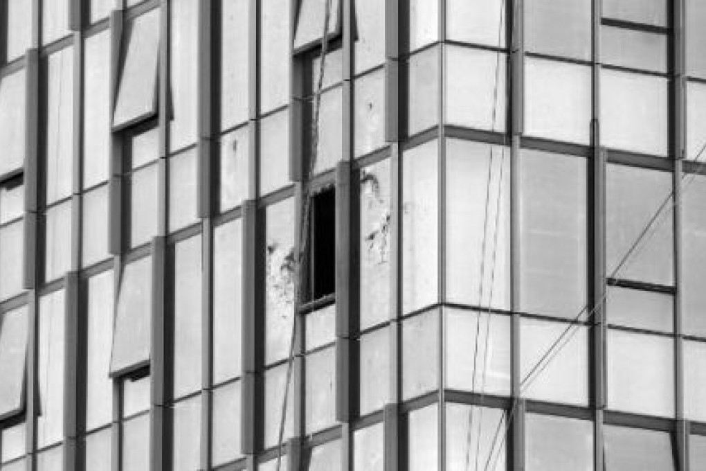 A sudden strong wind blew two window cleaners against a commercial building in Xian, killing them both. Photo: SCMP Pictures