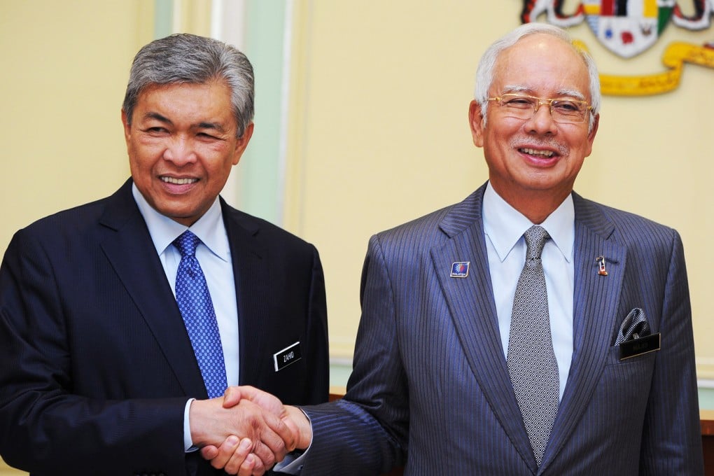 Malaysia's Prime Minister Najib Razak, right, shakes hands with his newly-appointed Deputy Prime Minister Ahmad Zahid Hamidi after the surprise reshuffle today. Photo: AFP
