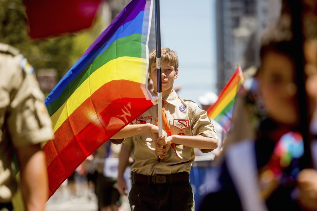 A Boy Scout carries a rainbow flag during a San Francisco gay pride festival last year. In 2013, the Boy Scouts of America decided to allow openly gay youth as scouts, but not gay adults as leaders. Photo: Reuters