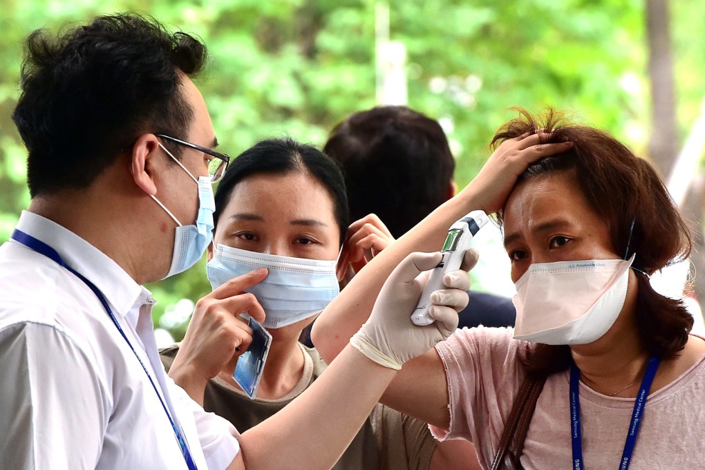 A hospital worker (left) checks the temperature of visitors to the Samsung Medical Centre in Seoul, where most of the Mers cases came from. The hospital recently resumed operations after a quarantine-related shutdown. Photo: AFP