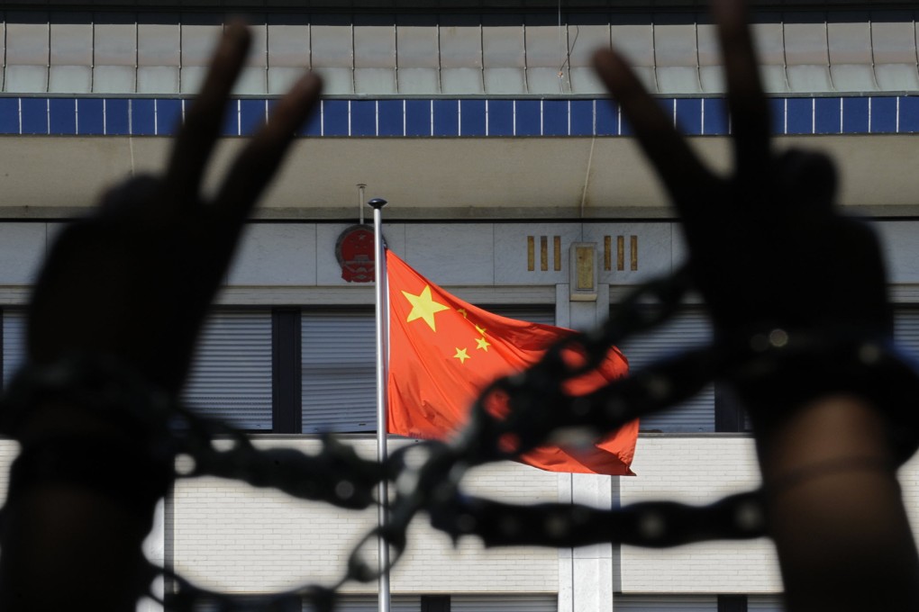 A Tibetan demonstrator flashes a V-Sign as he denounces the Olympic Games in Beijing on August 06, 2008 outside the embassy in Belgium. Photo: AFP