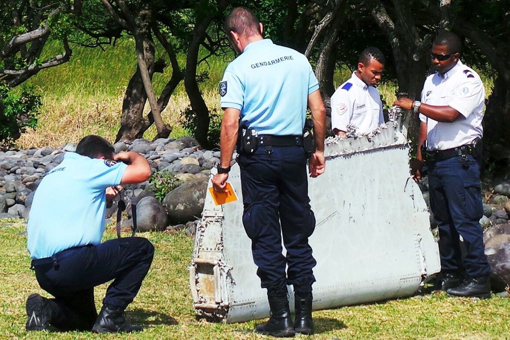 French gendarmes and police inspect the wing part that washed up on the beach in Saint-Andre, on the French island La Reunion, in the Indian Ocean. Photo: Reuters
