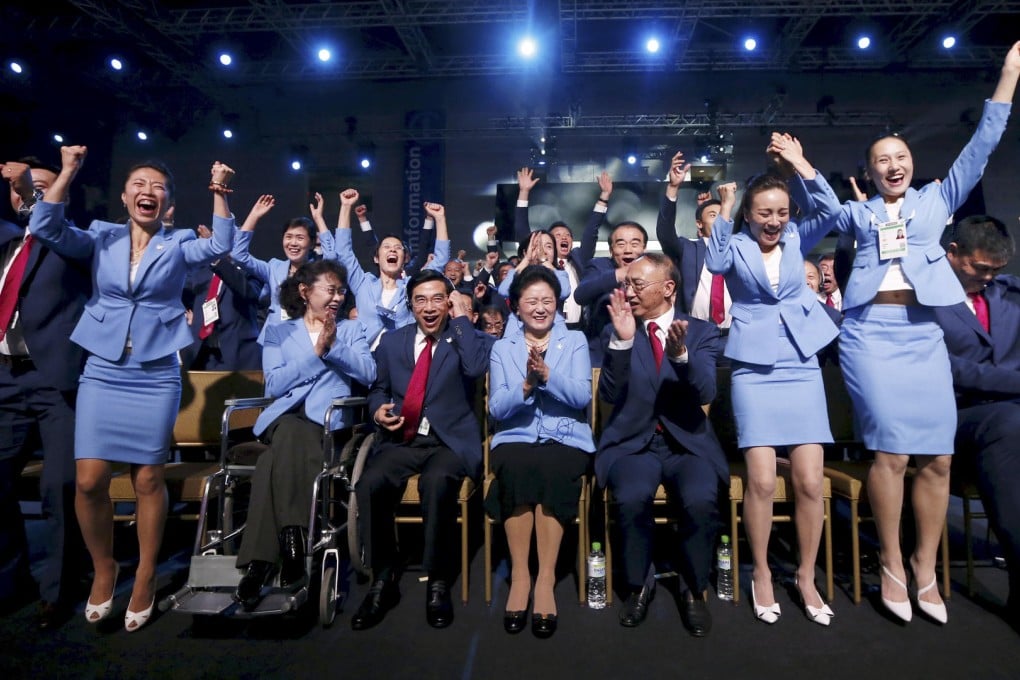 The Beijing delegation reacts to the win. Photo: Reuters