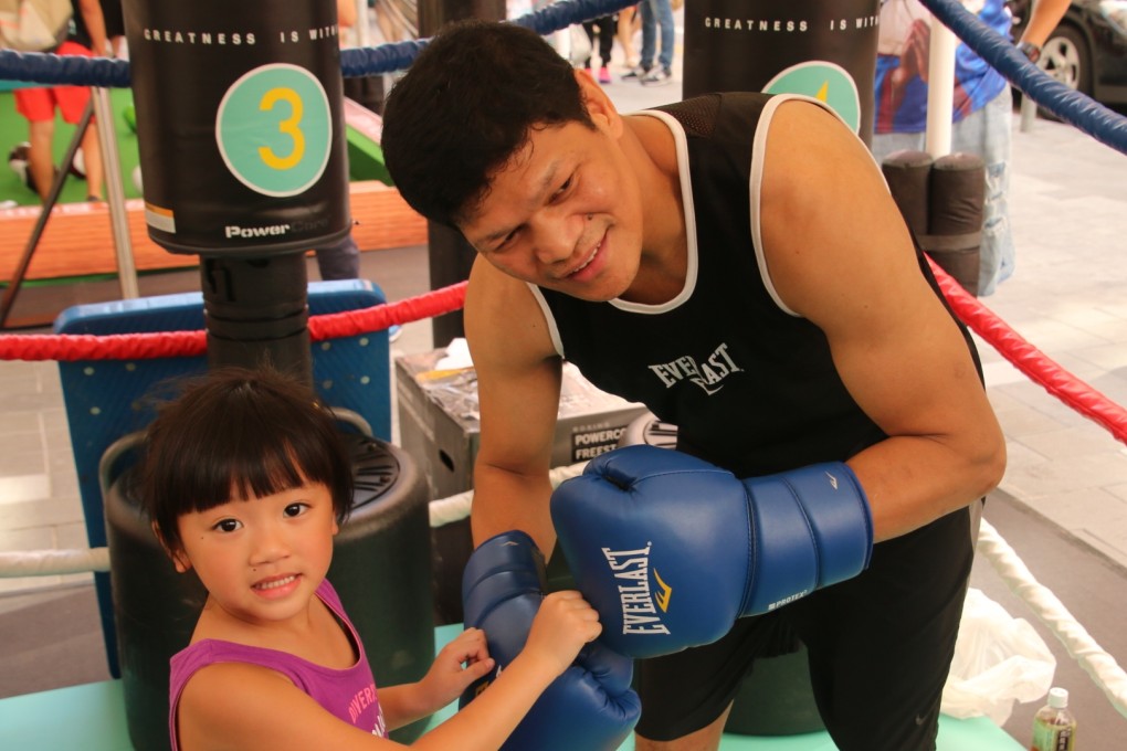 Former world champion Luisito Espinosa makes a new friend at the Fashion Walk in Causeway Bay. Photos: Unus Alladin