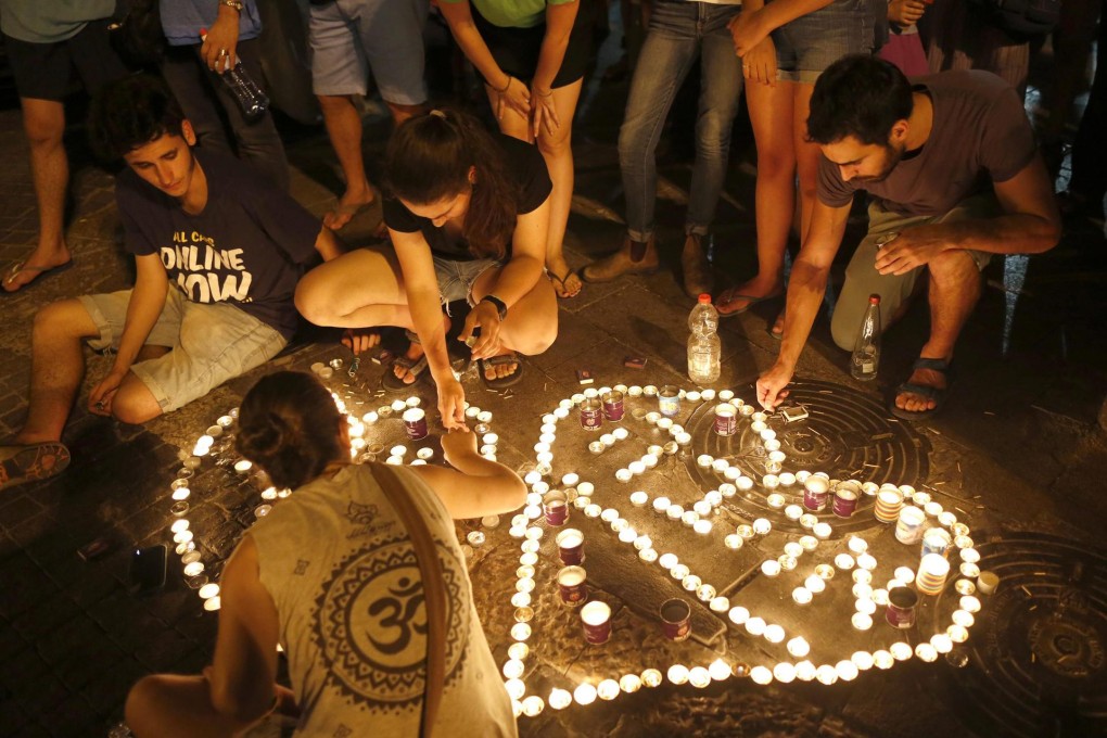 Israelis light candles after a teenager was killed.Photo: EPA
