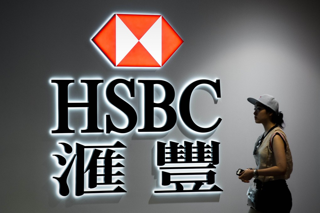 A woman walks past the HSBC logo in Hong Kong as the lender announces its results on Monday. Photo: AFP