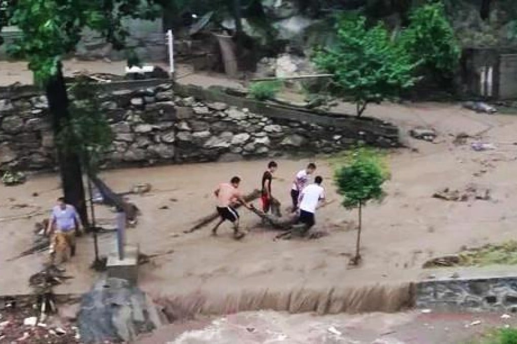 A victim of the floods is carried away by rescuers at the village in Shaanxi province. Photo: Xinhua