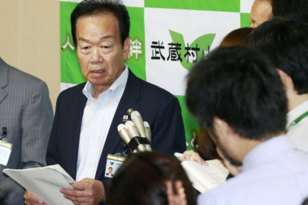 Masaru Fujino, mayor of the Musashimurayama suburb in Tokyo, signed the agreement to allow viruses to be handled at the laboratory. Photo: Kyodo