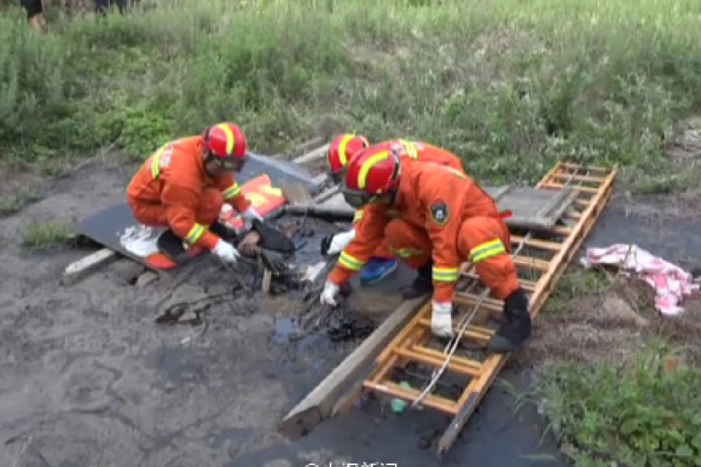 Firefighters used ladders to reach an old man who stumbled into an asphalt pond. He was rescued two hours later. Photo: SCMP Pictures