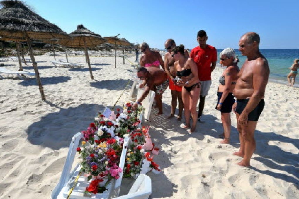 Tourists lay flowers in tribute to the people killed in the terror attack on a beach in front of the imperial Marhaba Hotel in al-Sousse in June. Photo: EPA