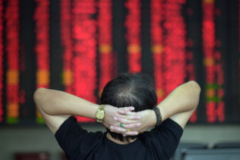 An investor surveys the stocks board at a Shanghai brokerage. Photo: AFP