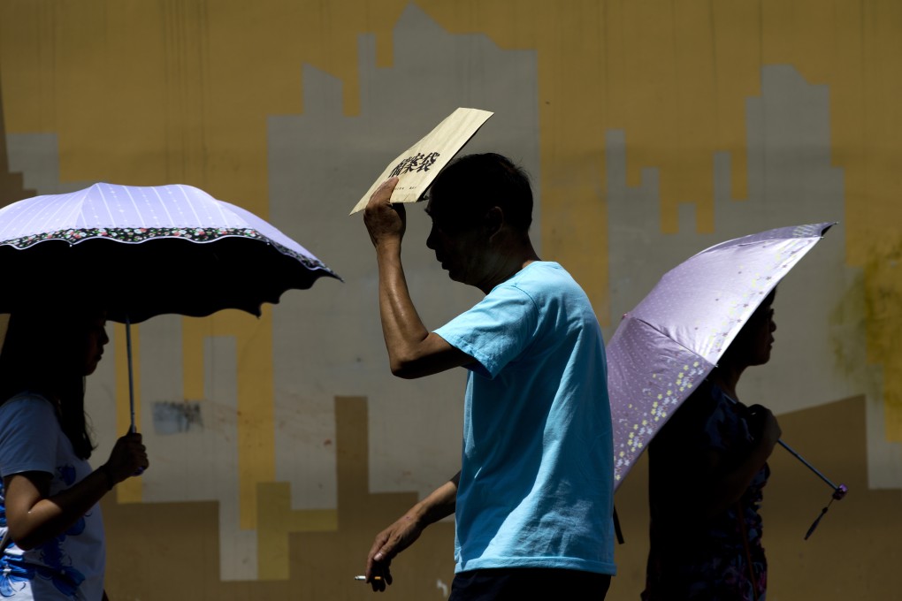 A man shields himself from the sun in northern China. A new study suggests winters are becoming warmer due to human activity. Photo: AP