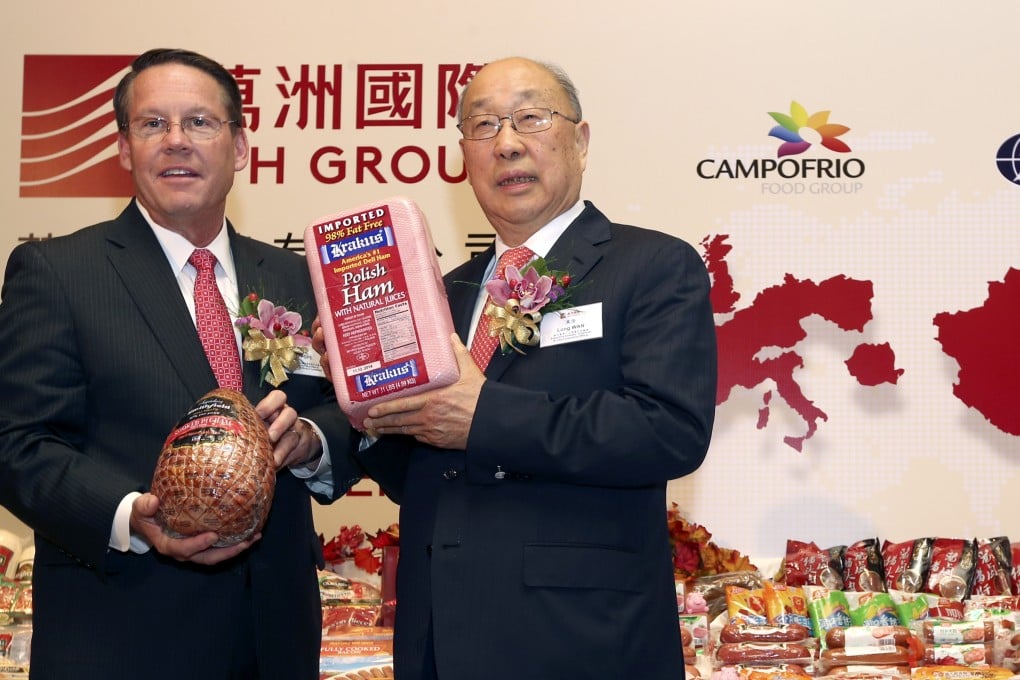 Larry Pope, president and chief executive officer of Smithfield Foods, poses with Wan Long, chairman and chief executive officer of pork conglomerate WH Group in Hong Kong. Photo: David Wong