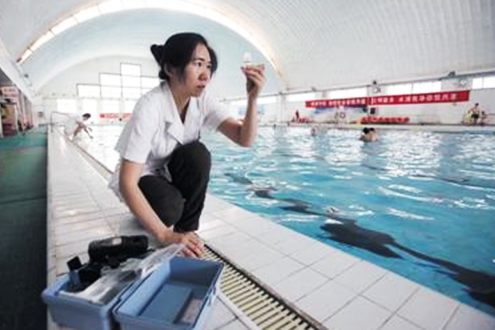 An inspector from Beijing's health authority checks a water sample at a public swimming pool. Photo: Xinhua