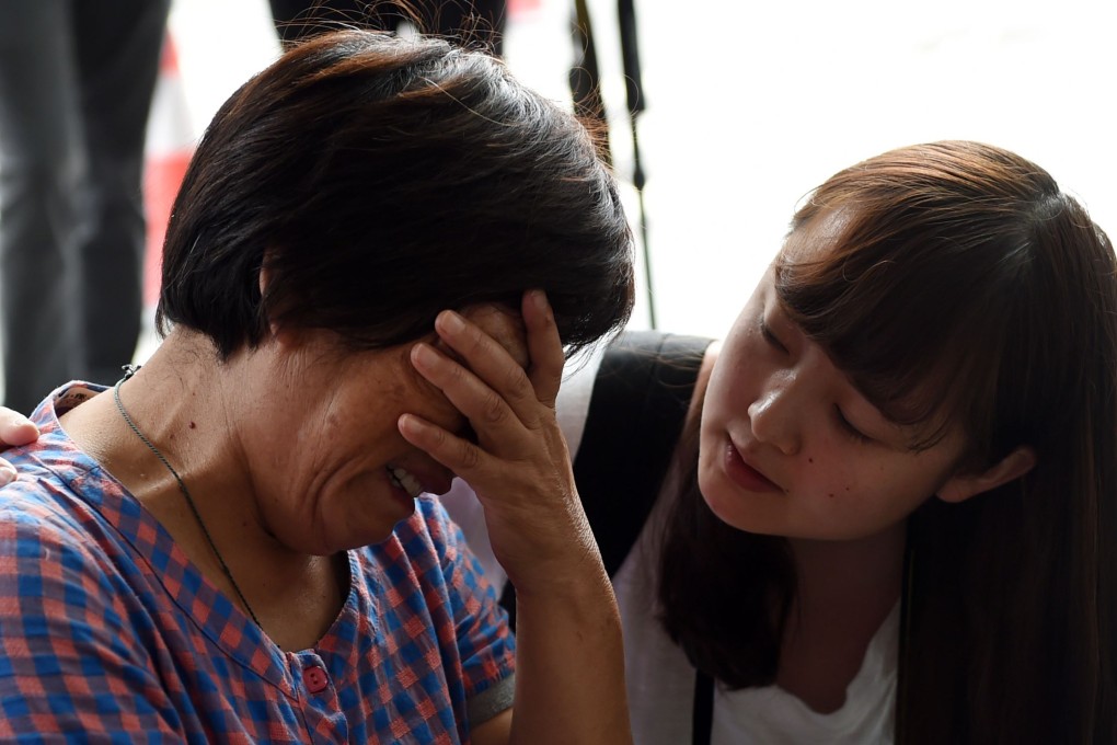 A relative of a Chinese passenger on board missing flight MH370 is consoled by a journalist outside Malaysia Airlines' Beijing office on Thursday. Photo: AFP