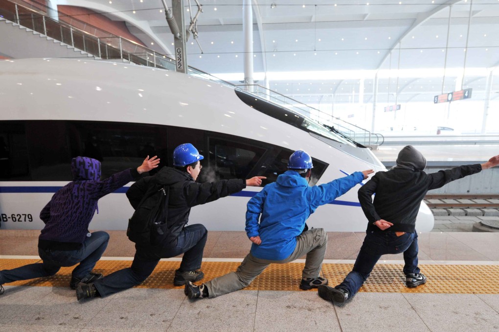 Passengers imitate the hand signals in a train station as China Railway Signal & Communication places its initial public offering at the bottom of the price range, having raised HK$10.8 billion in net proceeds. Photo: Xinhua