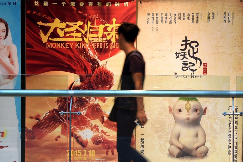 A man walks past a poster for Monster Hunt outside a cinema in Shenyang in the northeast of China. The film has become the biggest hit in Chinese cinema's history. Photo: Li Gang