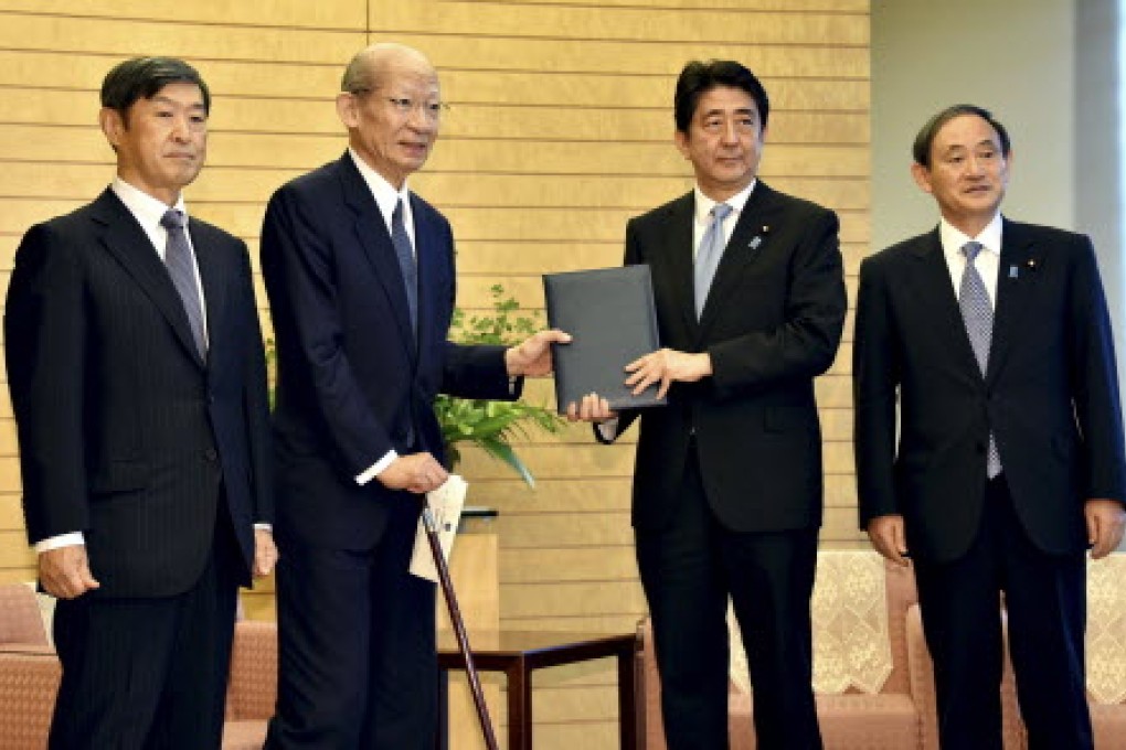 Japanese Prime Minister Shinzo Abe, second right, poses as he receives a 38-page report from Taizo Nishimuro, second left, chairman of the Japanese government's advisory panel on the history of the 20th century. Photo: AP