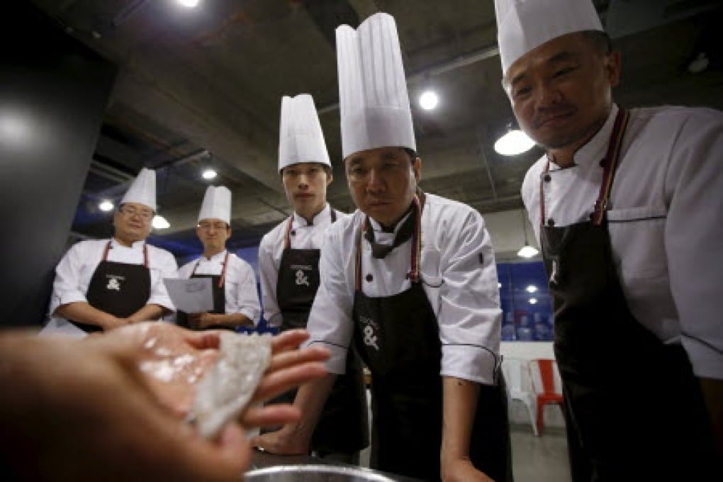 Lee Jin-soo (second from right), 53, looks at a small octopus as he and others take part in Happy Guys Cooking Class in Seoul, South Korea. Photo: Reuters