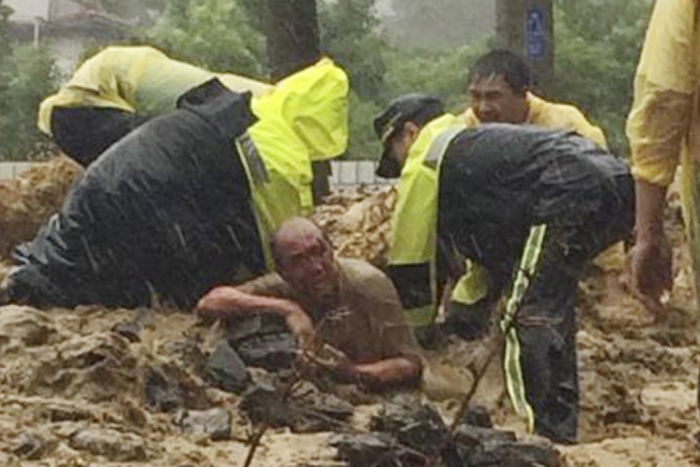 A man is buried to his waist in a mudslide as rescue workers rush to pull him to safety in Wulai, just outside the capital Taipei. Photo: AP