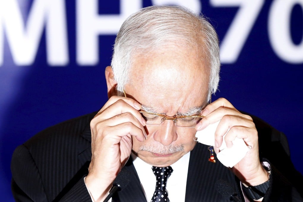 Malaysia's PM Najib Razak adjusts glasses before confirming the debris found on Reunion Island is from missing Malaysia Airlines flight MH370 in Kuala Lumpur, Malaysia. Photo: Reuters