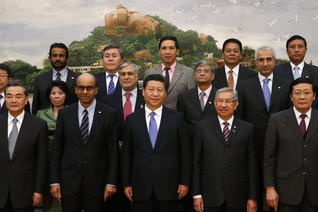 President Xi Jinping poses for photos with guests at the Asian Infrastructure Investment Bank launch ceremony at the Great Hall of the People in Beijing last year. Photo: Retures