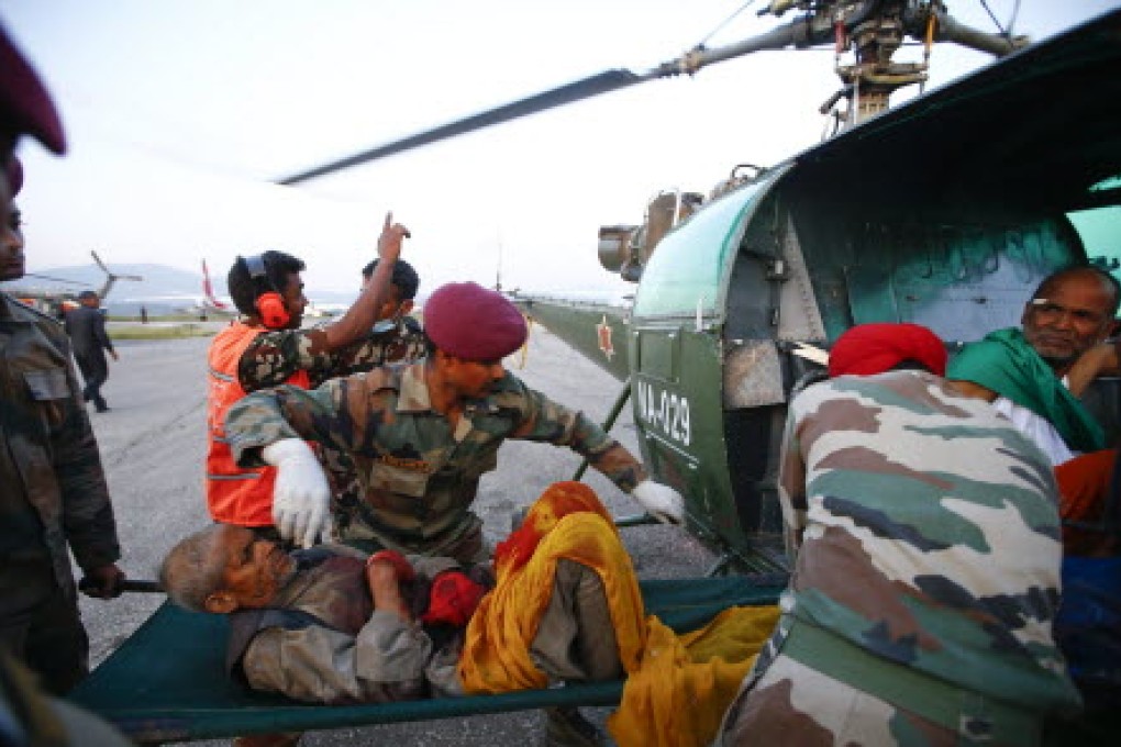 An injured man is moved on a stretcher into a helicopter at Kathmandu Airport after another powerful earthquake struck Nepal. Photo: AFP