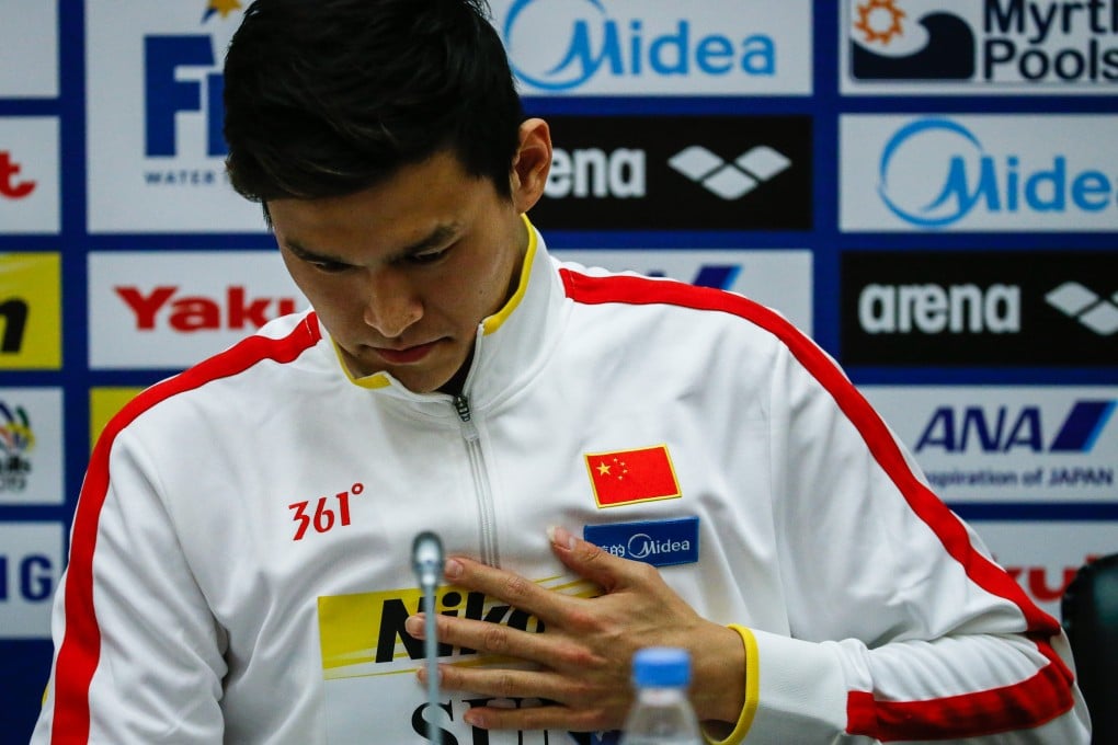 Sun Yang holds his chest at a press conference explaining his shock withdrawal from defending his 1,500m freestyle title.  Photo: Xinhua