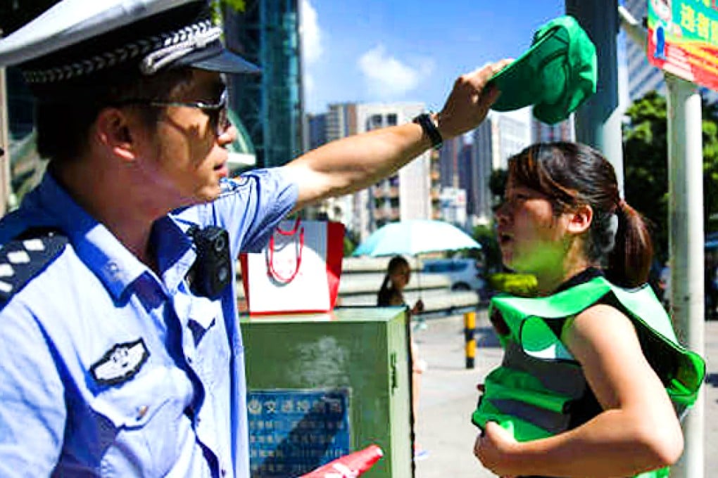 A jaywalker is issued with a green hat during the campaign in Shenzhen. Photo: SCMP Pictures