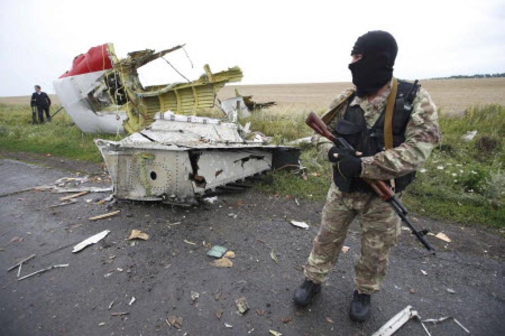 A pro-Russian separatist standing at the crash site of Malaysia Airlines flight MH17, near the settlement of Grabovo in the Donetsk region. Photo: Reuters