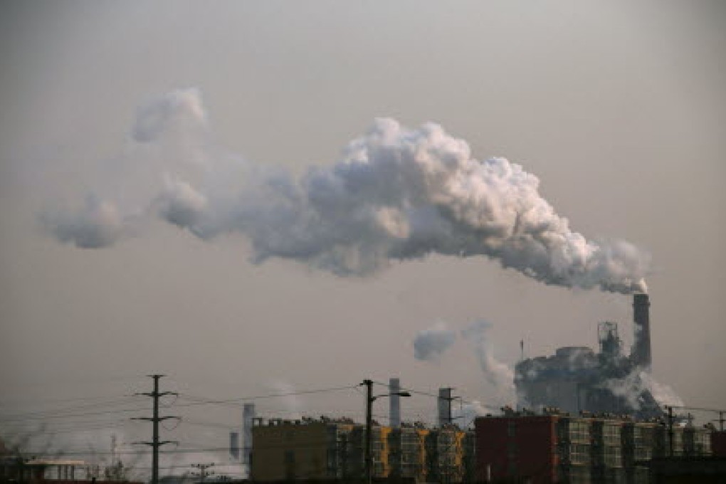 Smoke rises from a chimney of a steel plant next to residential buildings on a hazy day in Fengnan district of Tangshan. Photo: Reuters