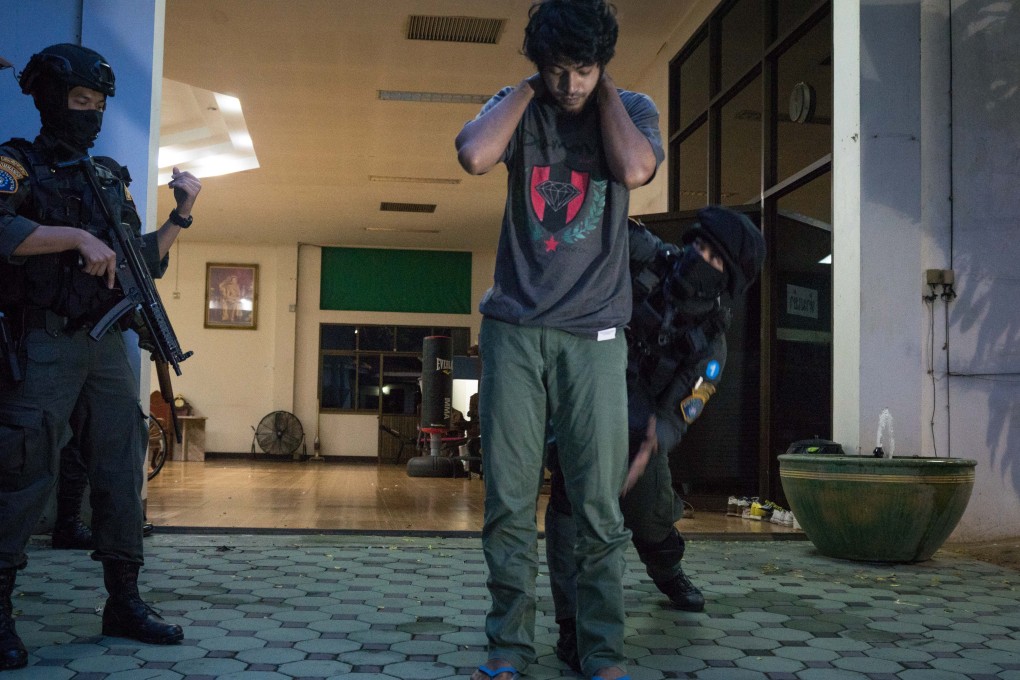 Members of Thailand's elite Crime Suppression Division police unit conduct a search during a raid on a suspect's house in Uthai Thani province. Photo: AFP