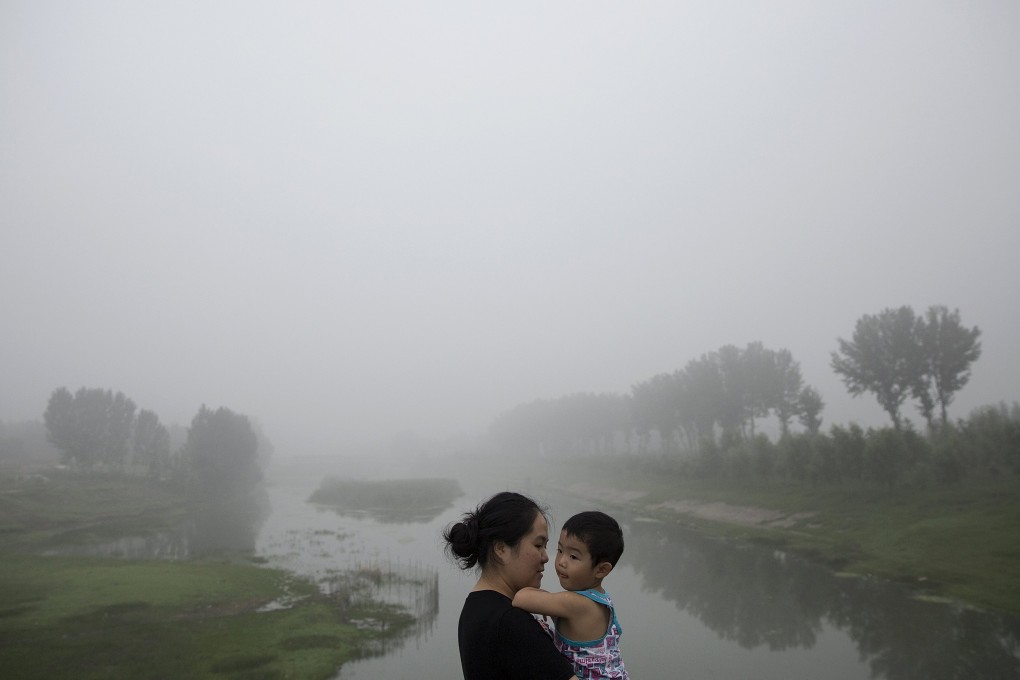 A mother and child take a stroll on a heavily polluted morning in Beijing. Photo: Reuters