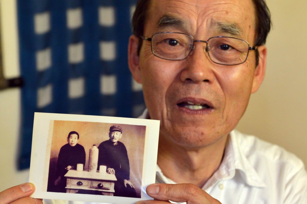 Yohachi Nakajima holds a picture of his Chinese adopted parents, at his residence in Tokyo. Now 73, Nakajima fights back tears when he thinks of his Chinese adopted mother and the farming village he once called home - a boy lost inside imperial Japan's crumbling empire. Photo: AFP