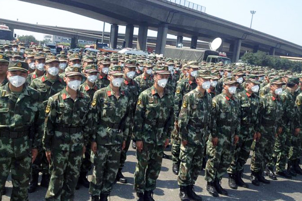 Armed police don protective masks as they prepare to tackle the blaze. Photo: PLA Daily