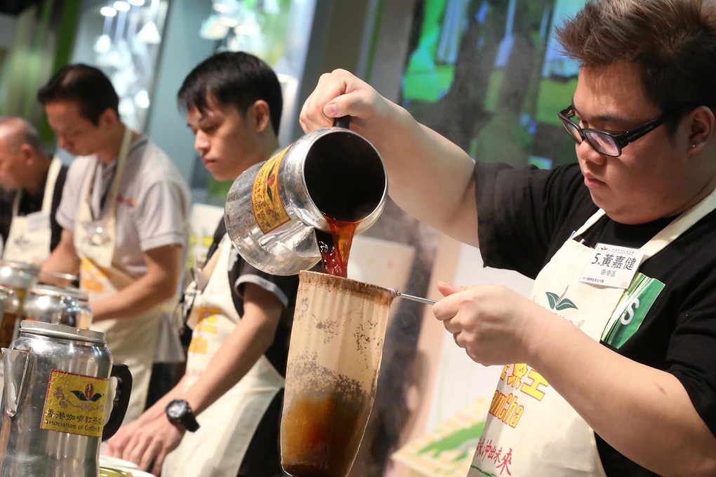 Wong Ka-kin (right) shows off his skills during the contest to make the best cup of Hong Kong-style milk tea. Photo: Edward Wong