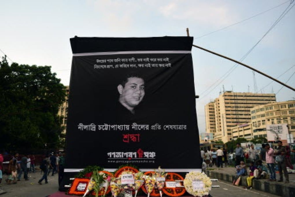 Floral wreaths are placed below a banner during a protest against the killing of blogger Niloy Chakrabarti, who used the pen-name Niloy Neel, in Dhaka. Photo: AFP